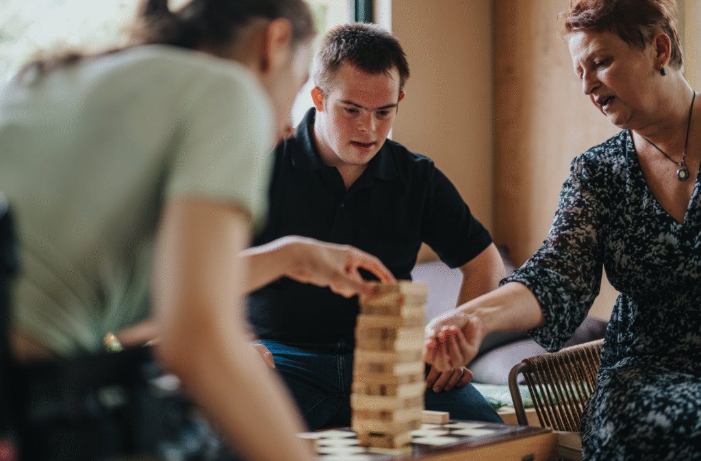 A Boy with Down Syndrome Playing Building Block Game with a Girl and Elderly Woman