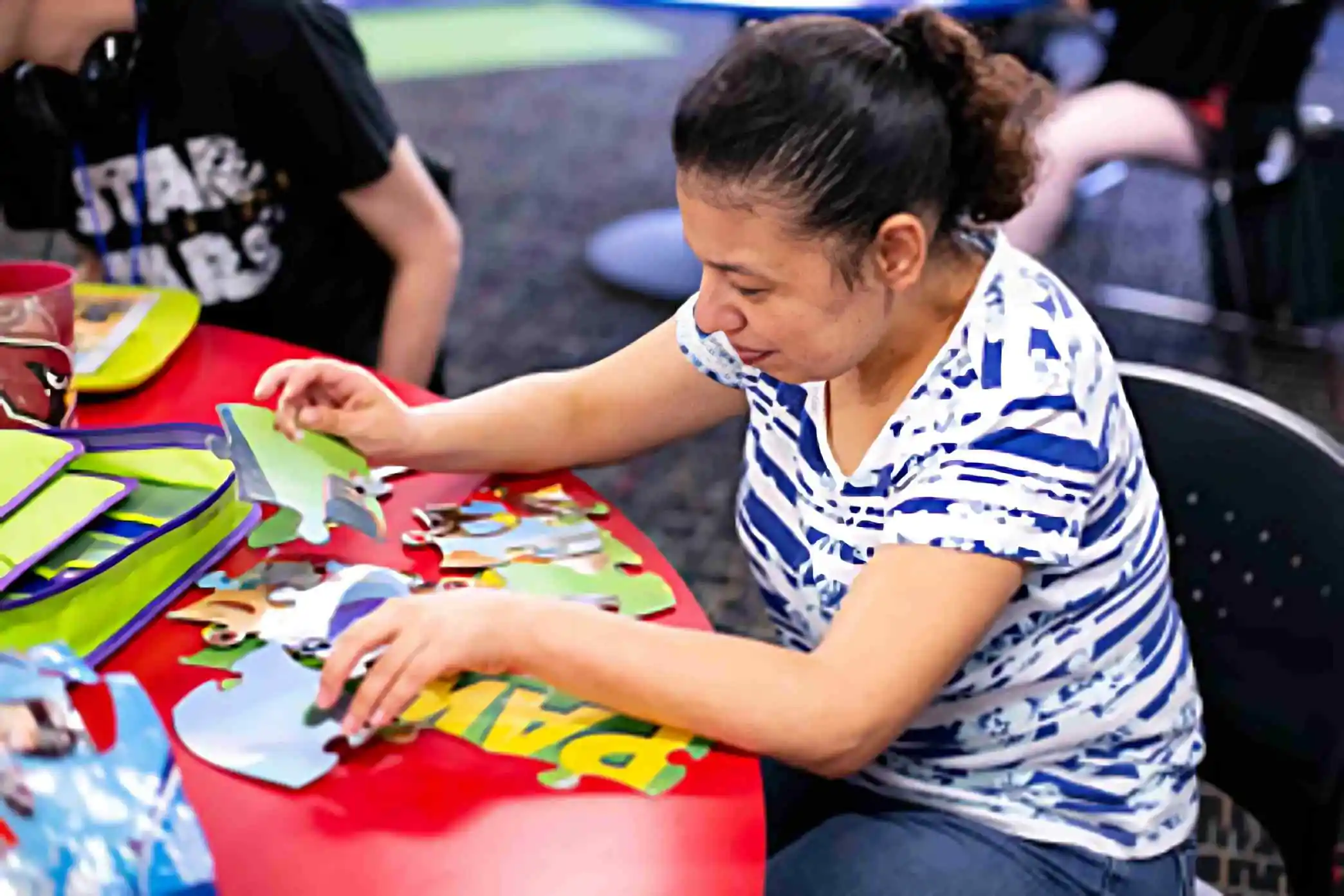 Adult with disabilities doing a puzzle in a group activity to address social isolation in adults with disabilities